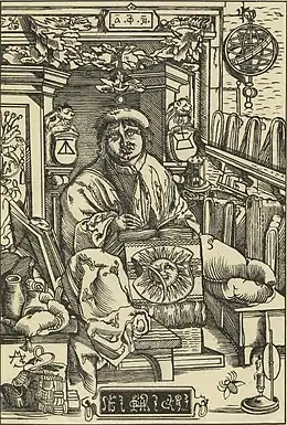 Gravure représentant un homme assis écrivant un livre au milieu d'une pièce encombrée.