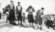 Quatre skieurs alpins en haut d'une piste vu de face