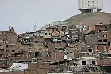 Photographie d'un bidonville installé à flanc de colline.