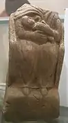 Statue de femme sans tête, assise tenant un enfant contre sa poitrine