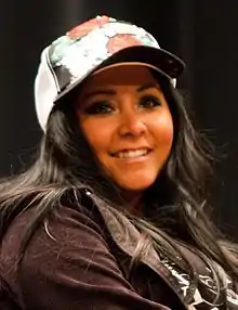 photo en buste d'une femme souriante portant une casquette