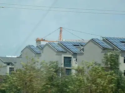 Immeubles en bandes serrées, panneaux solaires, banlieue de Tourfan. Juillet 2012
