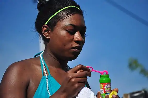 Une femme sortant d'un tube à bulles une baguette à bulles (Fremont Solstice Parade (en)).