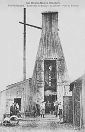 Photo noir et blanc montrant une grande tour en bois et son personnel.