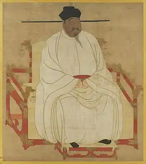 Peinture d'un homme corpulent assis sur un trône rouge décoré de têtes de dragons, vêtu d'une robe de soie blanche, de chaussures noires et d'un chapeau noir. Il porte une moustache et une barbiche