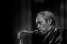Photo en noir et blanc d'un homme en train de jouer du saxophone