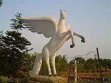 Sculpture moderne, blanche, d'un grand cheval ailé aux traits doux et enfantins.
