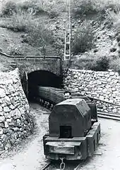 Une locomotive tirant ses berlines en sortant de la mine