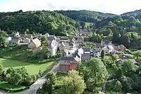 Photo du village de Sosoye montrant sa rue principale, l'église et laissant voir au premier plan la Molignée