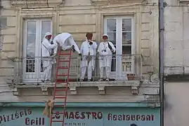 Quatre Soufflaculs montent sur un balcon, avec en premier plan l'échelle qui les a aidés à escalader.