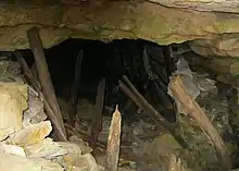 Entrée de mine en ruine, les boisage sont cassés