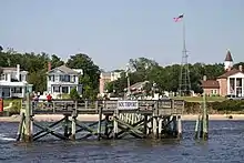 Un port maritime avec un ponton et plusieurs maison en fond.