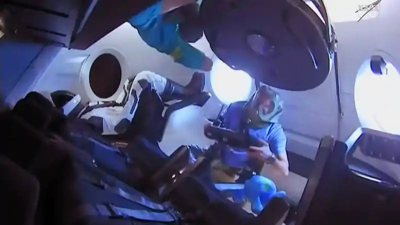 L'équipage de la station spatiale pénètre dans le vaisseau Crew Dragon après l'ouverture de l'écoutille.