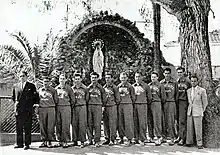 Photographie en noir et blanc des Spartiates d’Oran alignés devant une statue de la vierge