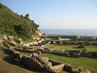 Au premier plan vestiges des casernes et des écuries, à l'arrière-plan bassin-vivier et triclinium