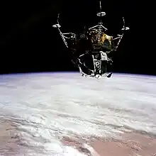 Photographie en couleur du module lunaire orbitant dans l'espace.