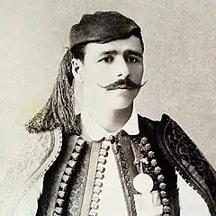 Un homme à moustaches pose avec un bandana et un costume traditionnel.