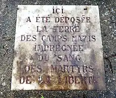 Plaque indiquant la présence de terre des camps nazis