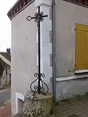 En face du n° 10 rue du Dr Charpentier, une croix repose sur un chapiteau d'un seul bloc provenant des ruines de Fontainejean.