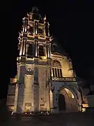 Photo de la façade de la cathédrale, illuminée de nuit.