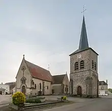 Photo depuis la rue de l'entrée de l'église Saint-Julien. A droite, le clocher de l'église Saint-Gervais