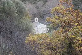 Vue aérienne d'une petite église aperçue par une trouée dans des arbres.
