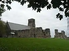 église flanquée à droite de murs en ruine