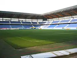 Photo de l'intérieur d'un stade vide de jour avec des panneaux publicitaires à plat au premier plan.