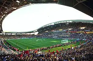 Le stade, tribunes emplies de spectateurs, lors d'un match de football.