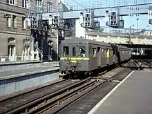 Un élément Standard alimenté par troisième rail entre en gare de Paris-Saint-Lazare sur les voies du groupe II en septembre 1976. La caténaire 25 kV est déjà en place.