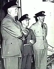 Trois hommes vêtus d'uniformes militaires clairs avec des peaked caps.