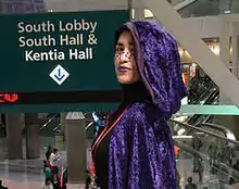Femme maquillée portant une cape violette.