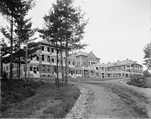 Photo en noir et blanc d'un bâtiment imposant aux nombreuses fenêtres.