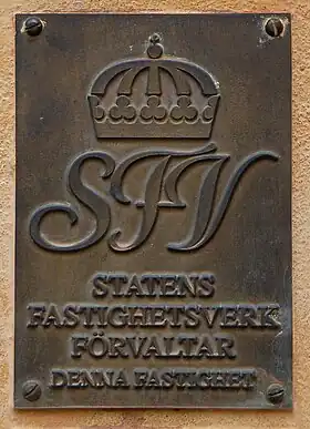 Plaque indiquant "L'administration des biens immobiliers de l'État Suédois gère ce bâtiment"