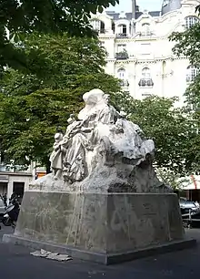 grande sculpture avec un homme au centre, sur son véhicule, étendant les bras et recevant les félicitations