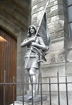 Statue de Jeanne d'Arc à l’étendard (1888) par Félix Charpentier devant la basilique Sainte-Jeanne-d'Arc.