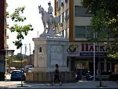 statue blanche d'un homme à cheval, au milieu d'une place
