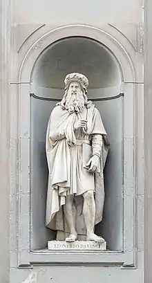 Statue en pied d'un homme barbu, placée dans une niche.