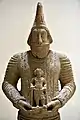 Statue de commandant militaire tenant une statue divine dans ses mains. Musée national d'Irak.