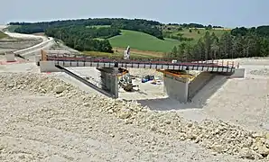 Construction d’un pont routier dans la tranchée de la plate-forme des futures voies.