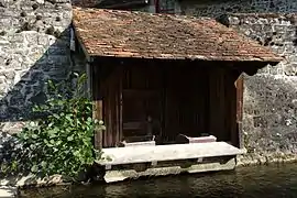 Un lavoir couvert de tuiles plates à Sainte-Suzanne.