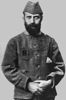 photographie noir et blanc : portrait d'homme barbu, en uniforme, un calot sur la tête