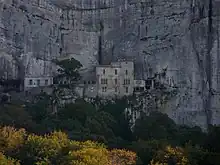 Le monastère vu de la plaine. Il est situé sur la plateforme, à droite de la grotte.