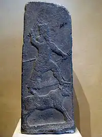 Adad sur son animal-symbole, le taureau, tenant des foudres dans ses mains, stèle d'Arslan Tash, VIIIe siècle av. J.-C., musée du Louvre.