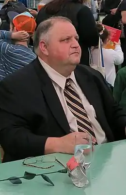 Un homme assis derrière une table