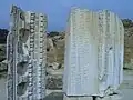 Éléments sculptés et fragments d'inscription de l'entablement et de la corniche.