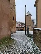 Étroit passage entre la tour et la première maison.