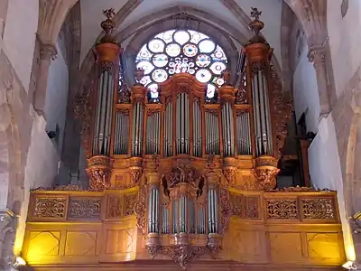 Photographie d'un orgue situé sur une tribune dans une église en grès.