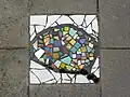 Mosaïque sur le trottoir au no 140