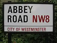 Plaques de rue à Londres de Abbey Road. Le district postal et le borough duquel la rue dépend, sont inscrits en rouge.